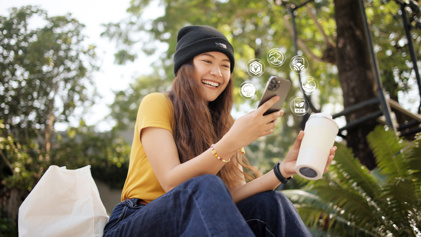 GS1 Graded Duurzaamheid Vrouw Kijkt Lachend Op Smartphone HIGHRES Met Iconen